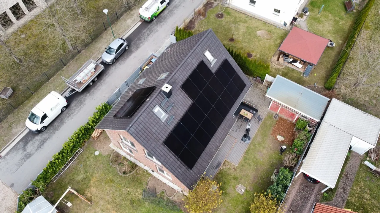 Luftaufnahme einer schwarzen Photovoltaikanlage auf einem Satteldach
