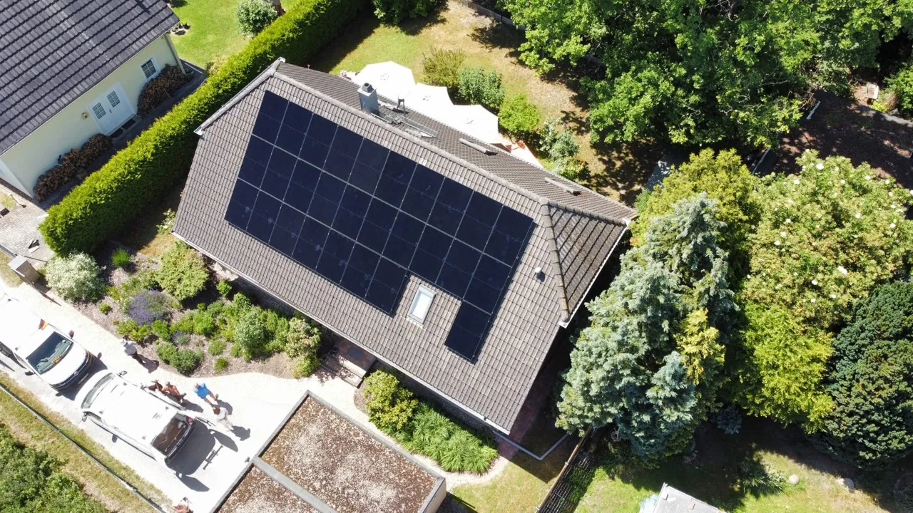 Luftaufnahme einer großflächigen Photovoltaikanlage auf einem Wohnhaus