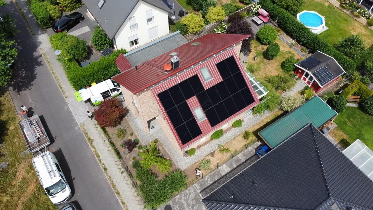 Luftaufnahme einer Photovoltaikanlage auf einem individuell geschnittenen Wohndach