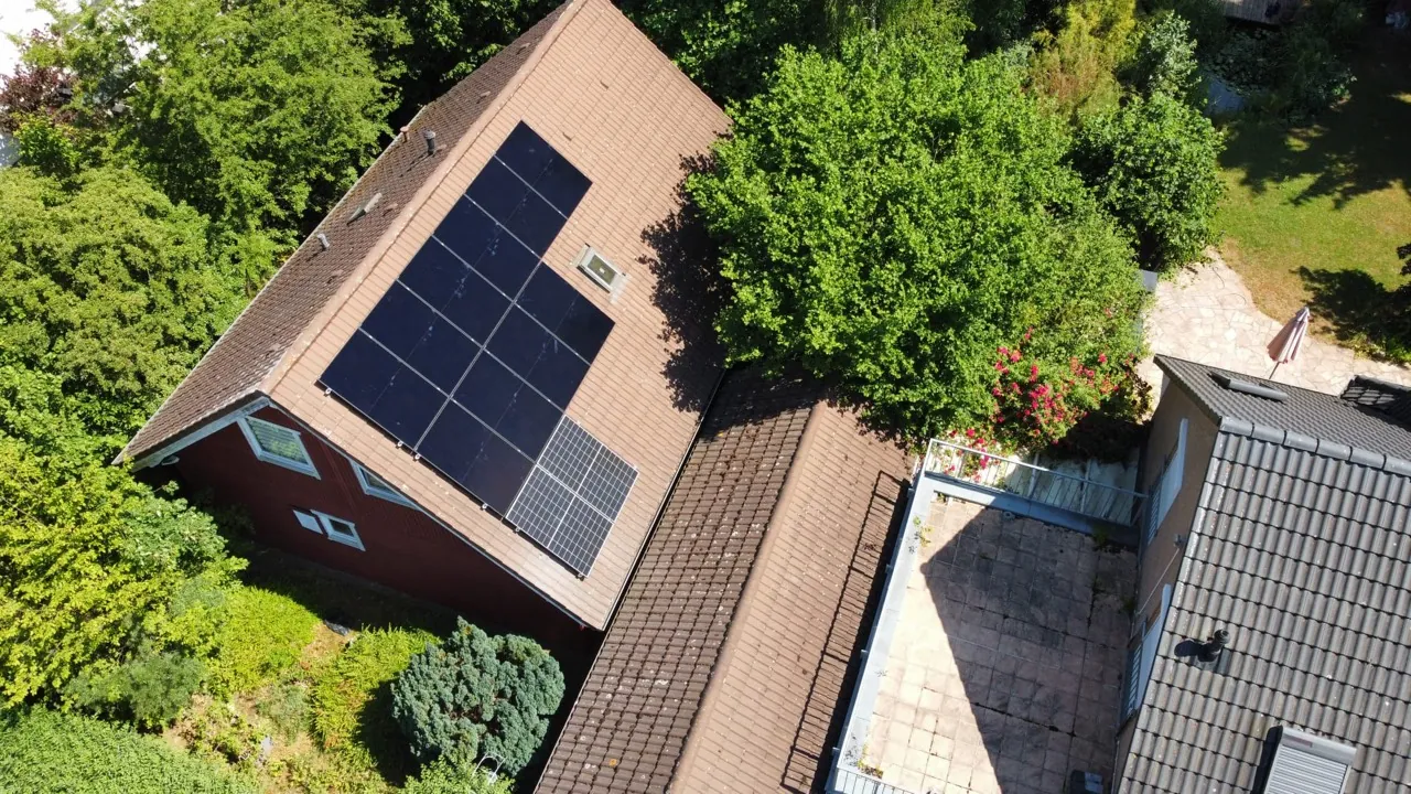 Luftaufnahme verschiedener Photovoltaik-Modulflächen auf einem Wohngebäude